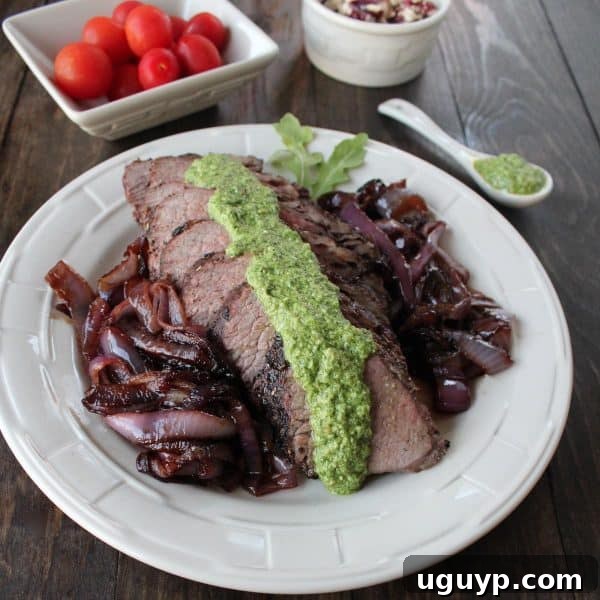 Grilled Tri Tip Steak with Arugula Pesto - A mouth-watering view of a perfectly grilled tri-tip steak, generously topped with fresh arugula pesto.