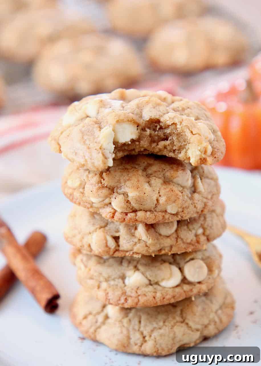 Stacked up pumpkin spice cookies on plate with cinnamon sticks