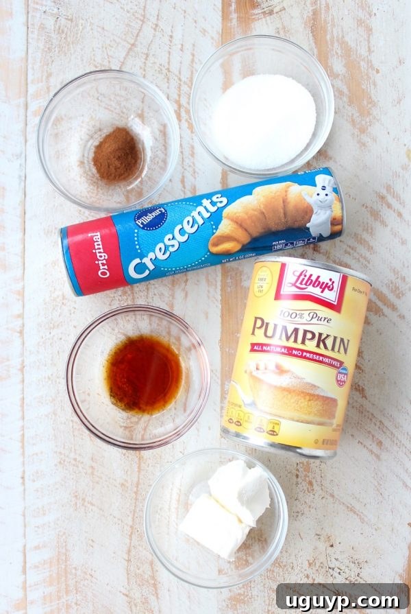 All the ingredients for pumpkin filled pastries laid out on a wooden surface.