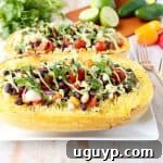 Mexican Stuffed Spaghetti Squash ready to serve, showing the colorful filling and avocado drizzle.