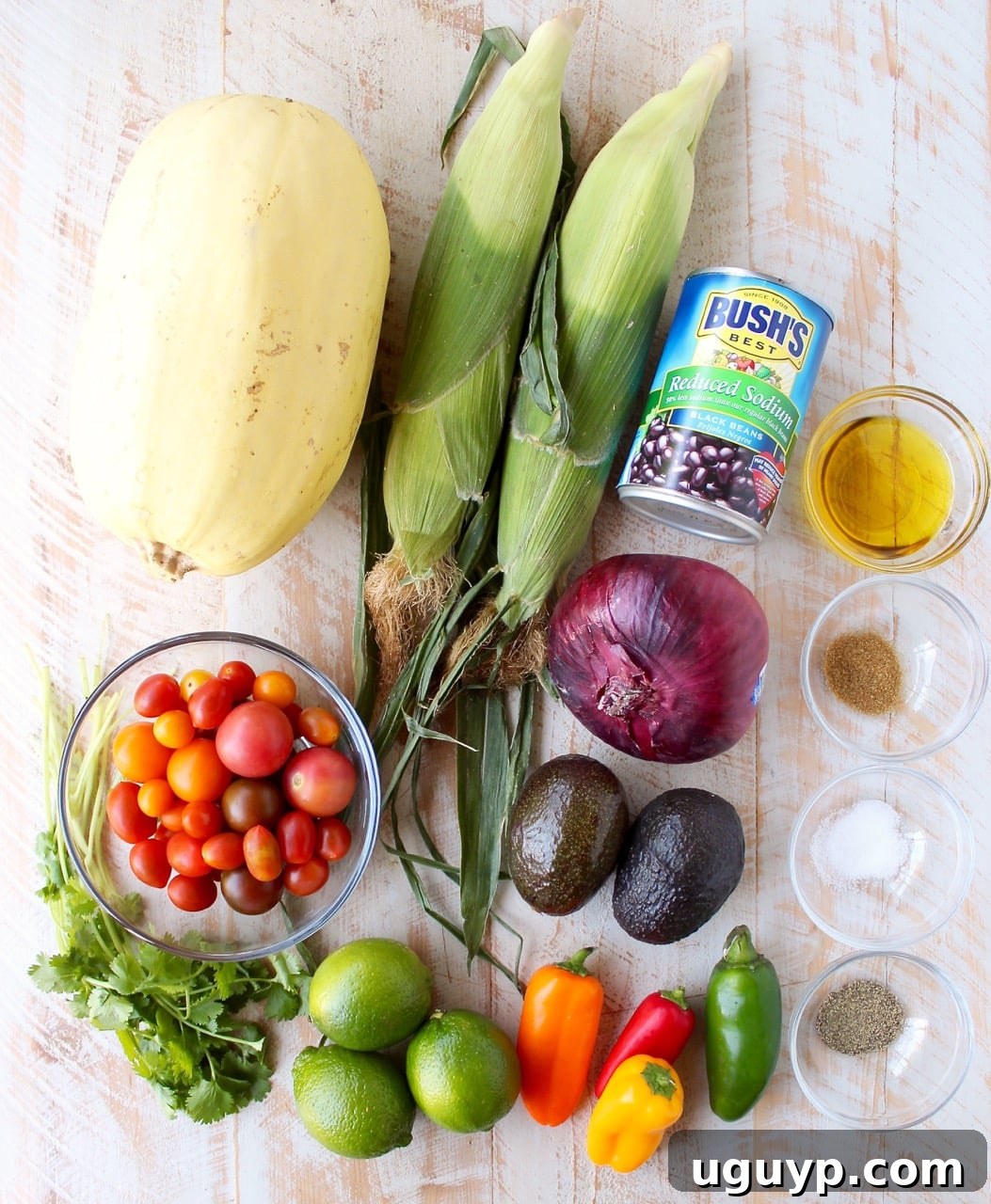 Fresh ingredients laid out on a white wooden board for making Mexican stuffed spaghetti squash.