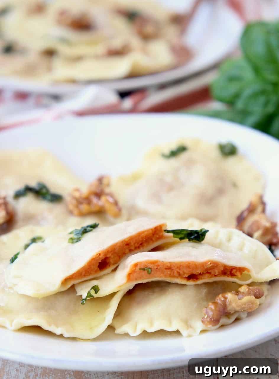 Sweet potato ravioli sliced in half on plate with whole raviolis and walnuts