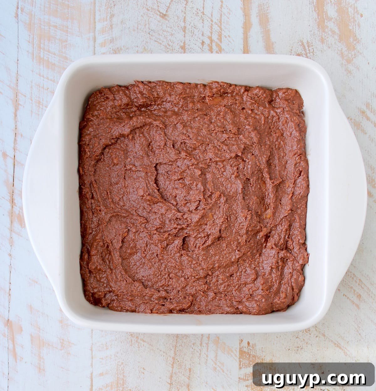 Rich, thick raw gluten-free sweet potato brownie batter in a bowl, ready to be spread into a baking dish.