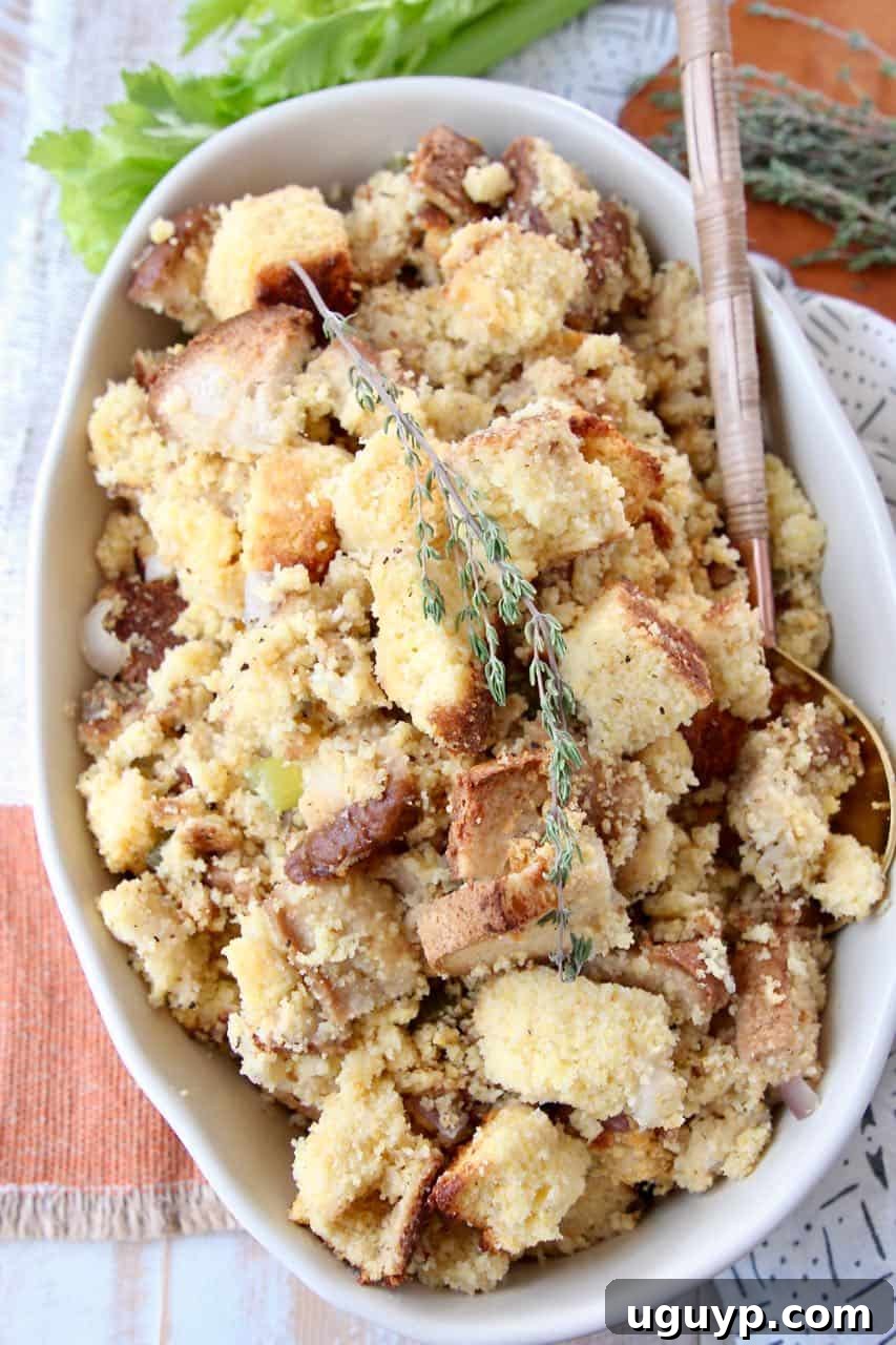 A close-up overhead shot of savory gluten-free cornbread stuffing in a large oval serving bowl, showcasing its delicious texture and herbs.