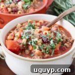 A bowl of Pasta Fagioli soup with a copper spoon, indicating a delicious meal.