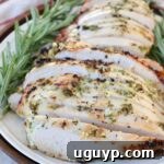 sliced turkey breast on plate with fresh rosemary