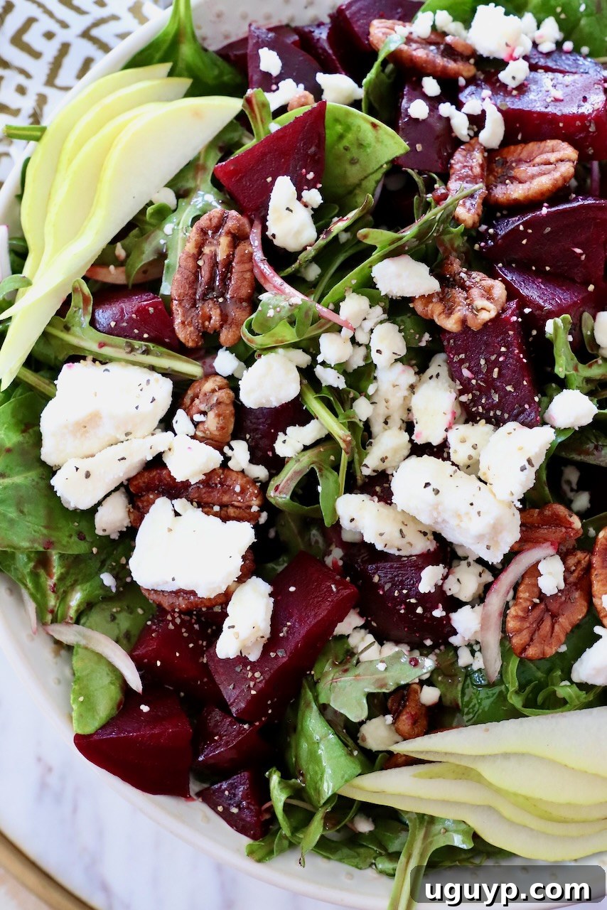 A vibrant beet salad in a bowl, generously topped with roasted beets and crumbled feta cheese, ready to be served.