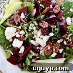 A delightful beet salad in a bowl, generously topped with candied pecans and crumbled feta cheese.
