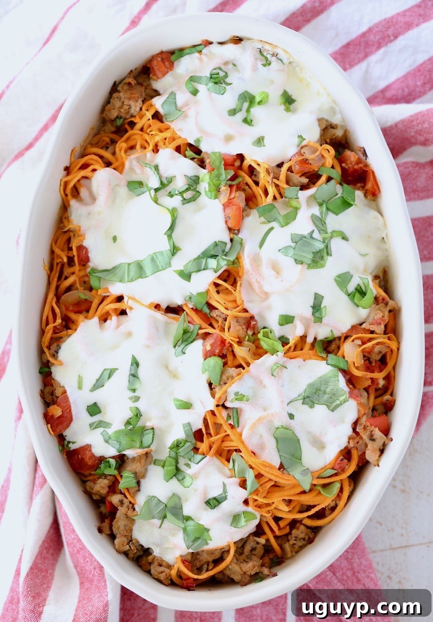 Italian casserole with sweet potato noodles, topped with mozzarella cheese in an oval baking dish