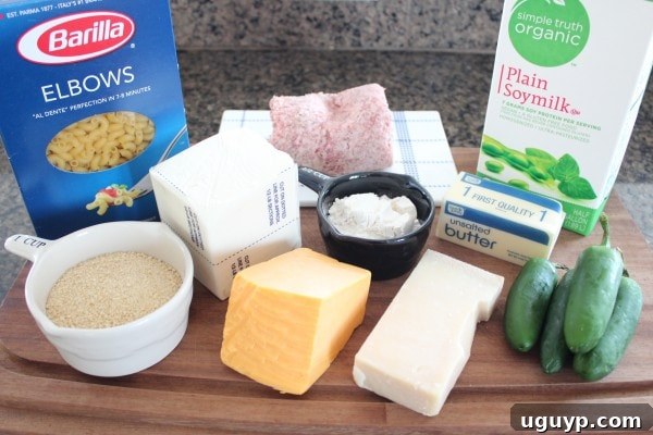 Ingredients laid out for Sausage Jalapeño Macaroni and Cheese, including jalapeños, elbow macaroni, butter, flour, milk, cream cheese, cheddar, parmesan, sausage, and breadcrumbs.