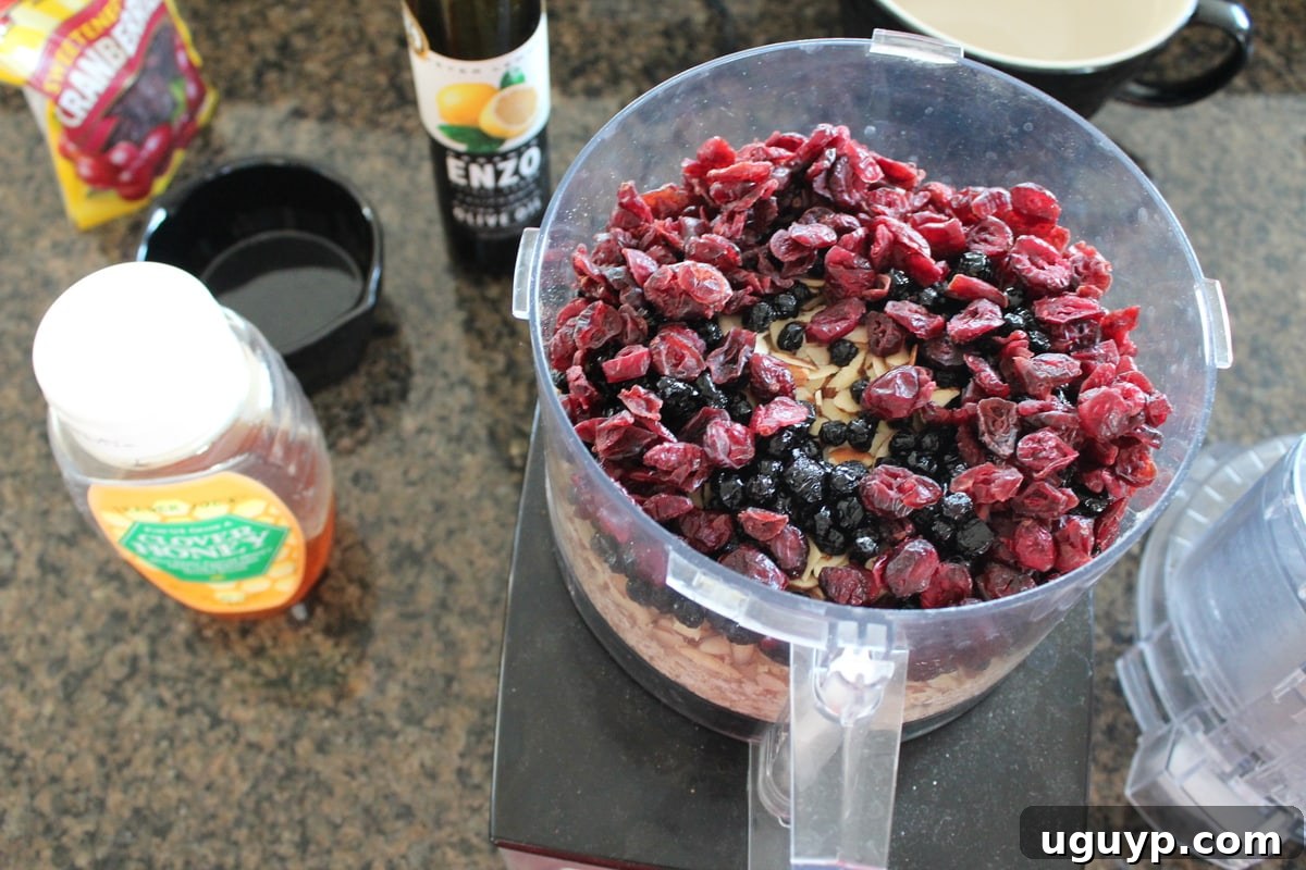 Granola bar mixture being blended in a food processor, showing the sticky consistency.