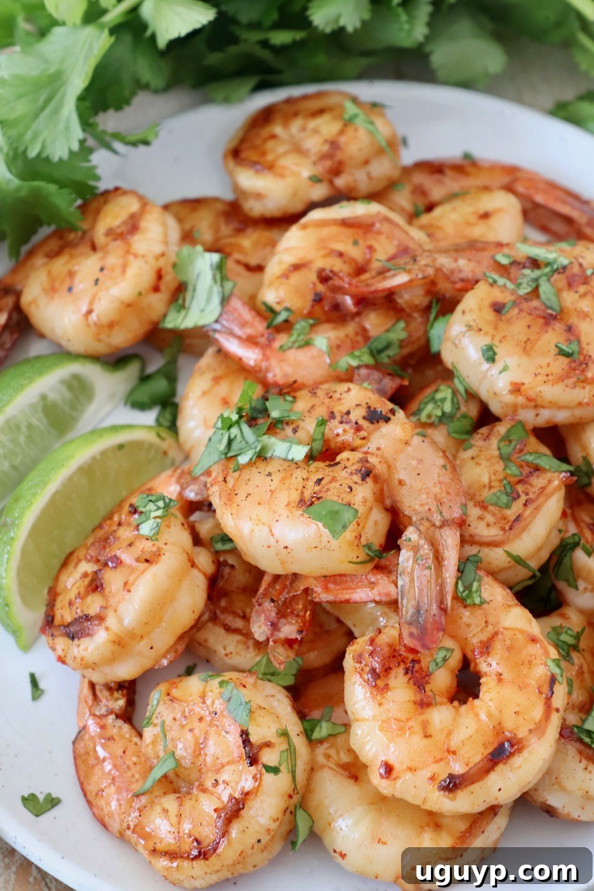 Piled grilled shrimp garnished with fresh cilantro, ready to serve