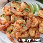 cooked shrimp piled up on plate with lime wedges