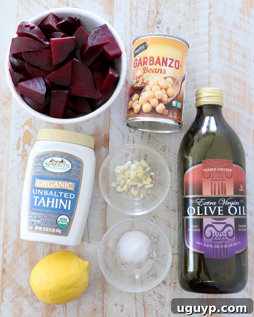 Ingredients for beet hummus laid out on a white wooden board before preparation.