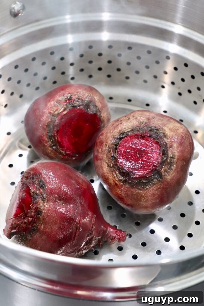 Raw beets being placed into a steamer basket, ready for cooking.
