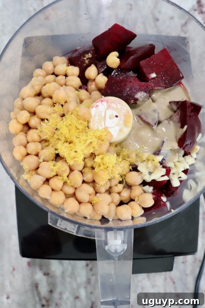 All the beet hummus ingredients gathered inside a food processor, ready for blending.
