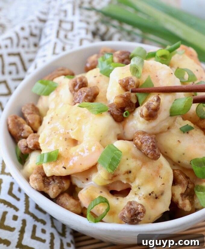A bowl of delectable Honey Walnut Shrimp with chopsticks, ready to be enjoyed.