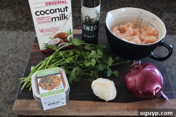 Essential ingredients for homemade Chicken Curry Meatballs laid out on a cutting board