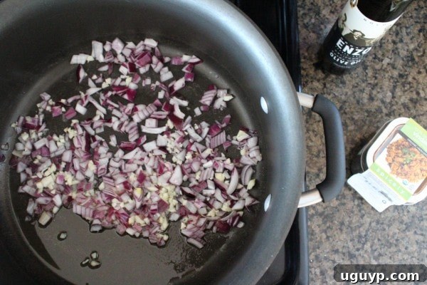 Red onion and minced garlic sizzling in olive oil in a pan, starting the Vindaloo sauce