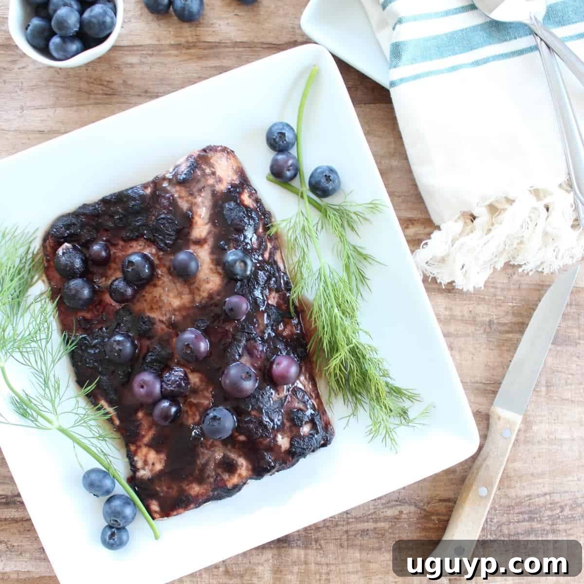 Delicious Blueberry BBQ Salmon Recipe on a serving plate, garnished with fresh blueberries.