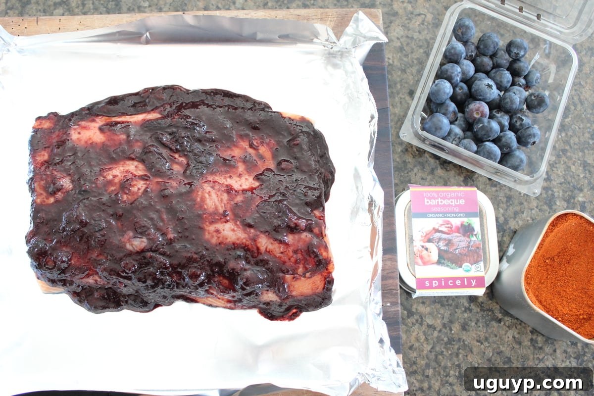 Salmon in a foil basket with blueberry BBQ sauce poured over it.
