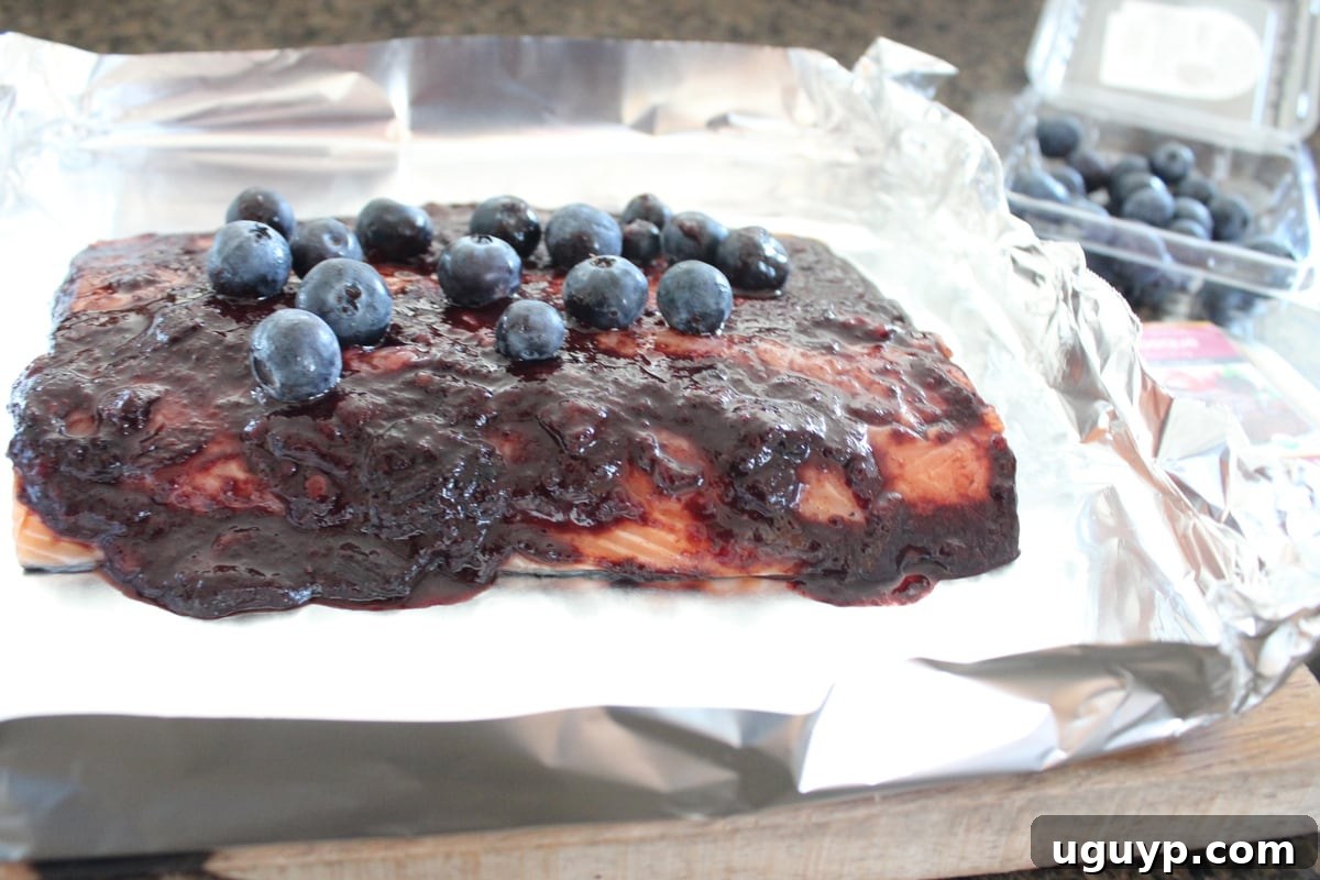 Remaining fresh blueberries sprinkled over the sauced salmon in a foil basket.