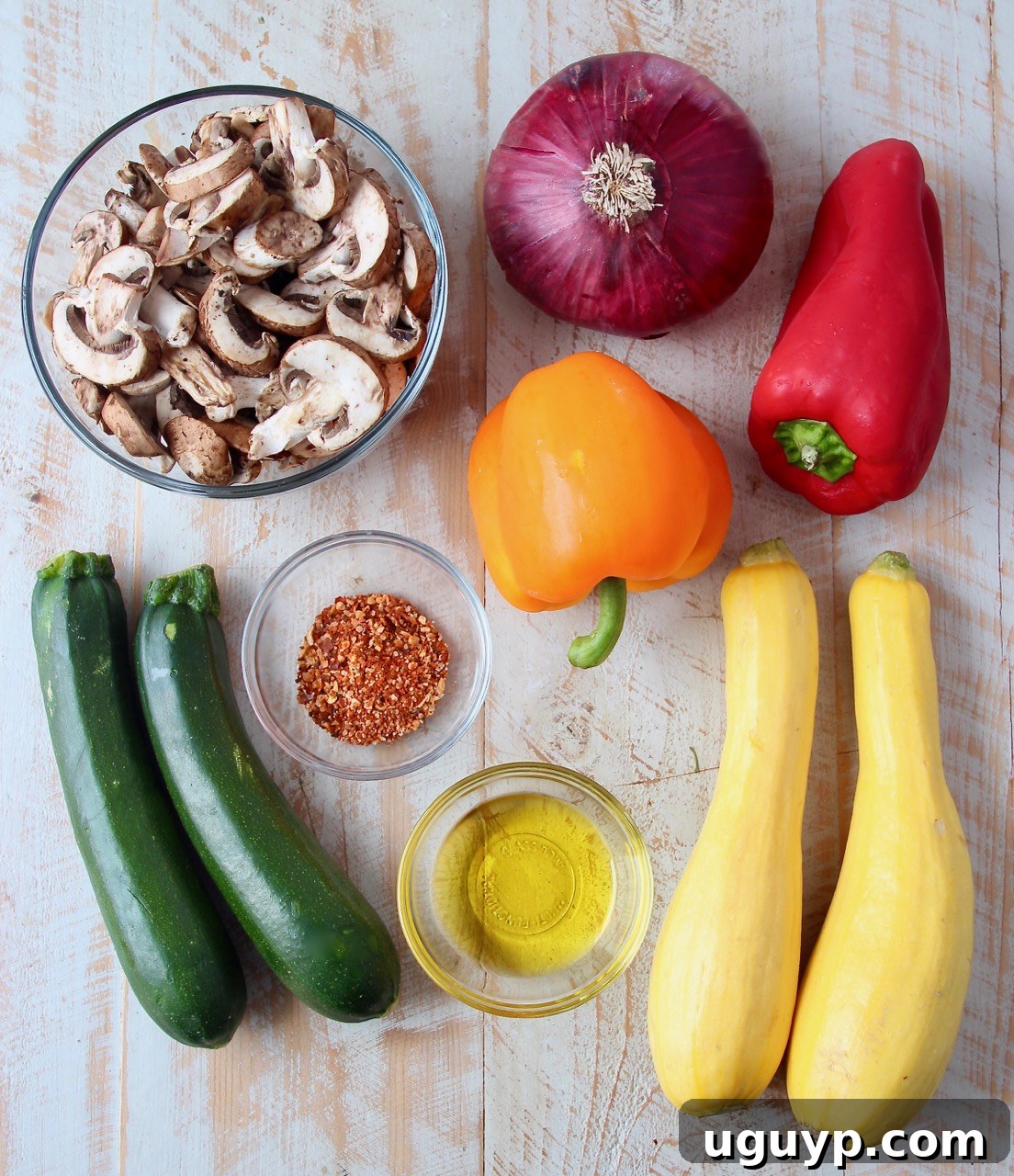 ingredients for grilled vegetable skewers on a white wood board