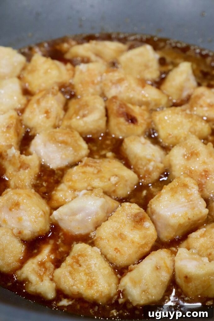 cooked pieces of chicken in orange sauce in skillet