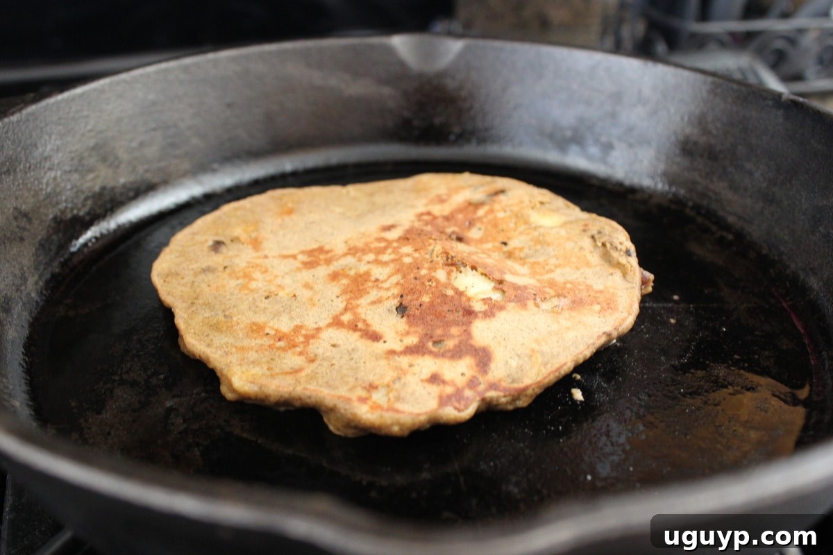 Flipping a banana date protein pancake on the skillet