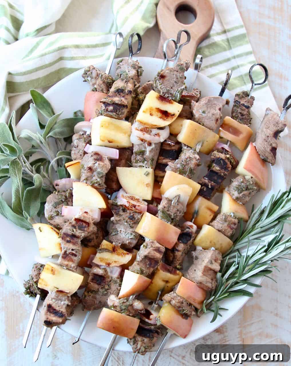 Stacked grilled pork skewers with fresh herbs, showcasing the tender pork, apples, and shallots