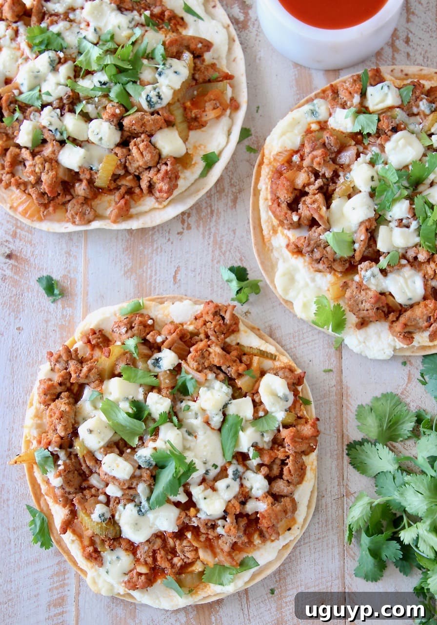 Overhead shot of grilled buffalo turkey flatbread pizzas topped with fresh cilantro