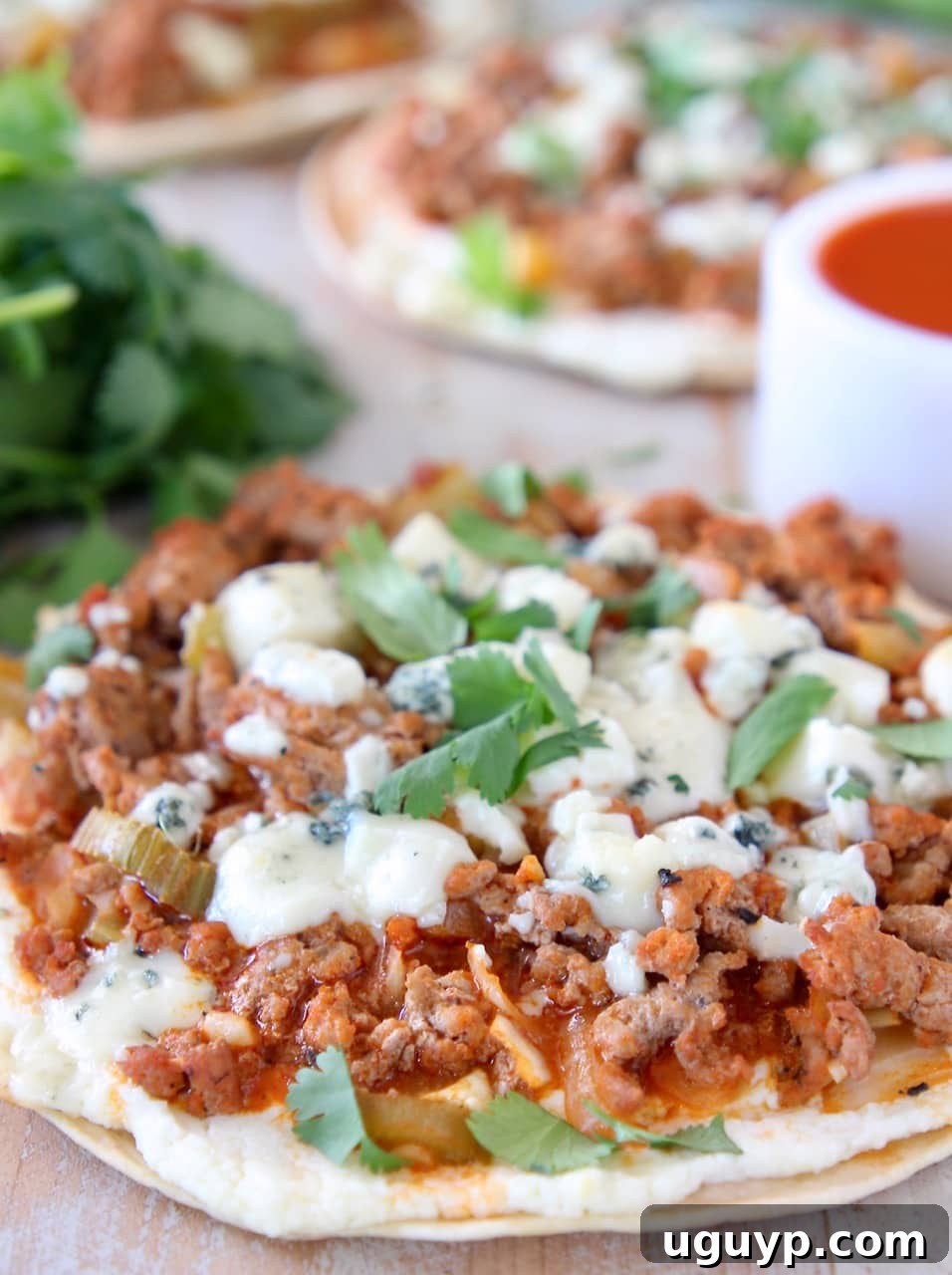 Cheesy buffalo turkey flatbread topped with fresh cilantro