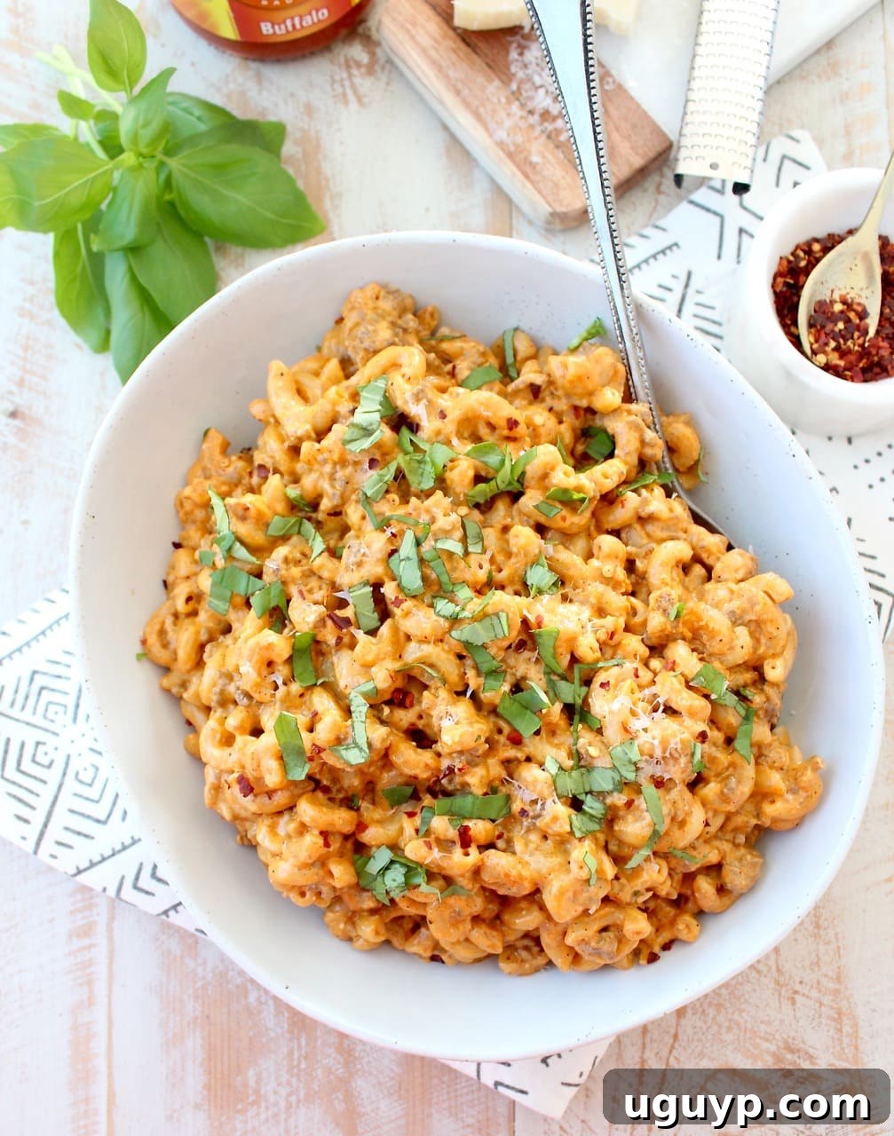 Buffalo Cheeseburger Macaroni in a bowl with a spoon, ready to be enjoyed.
