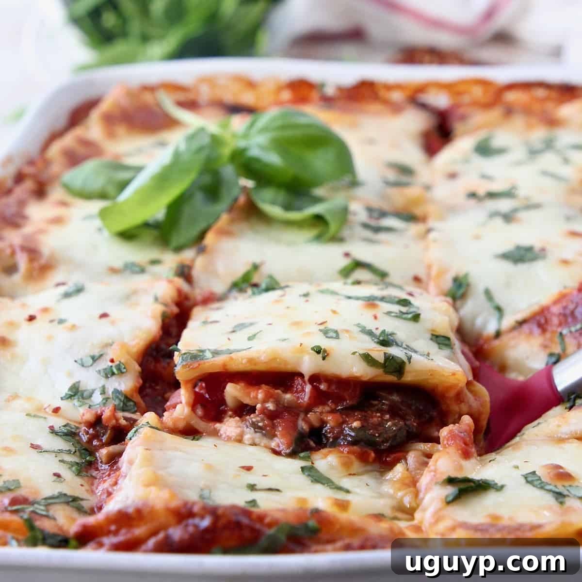 slice of vegetable lasagna being lifted out of casserole dish