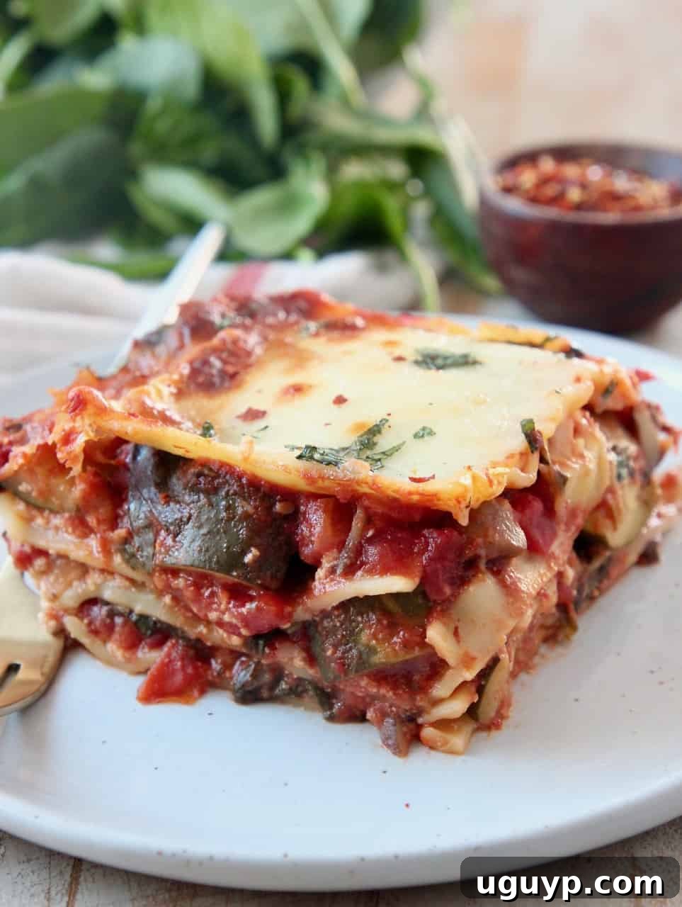 slice of vegetable lasagna on plate with fork