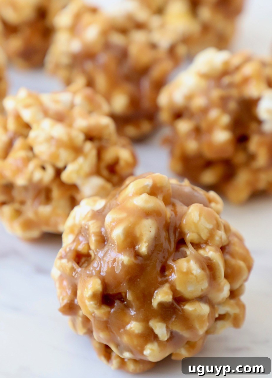 Delicious Peanut Butter Popcorn Balls arranged on a white marble serving tray, ready to be enjoyed.