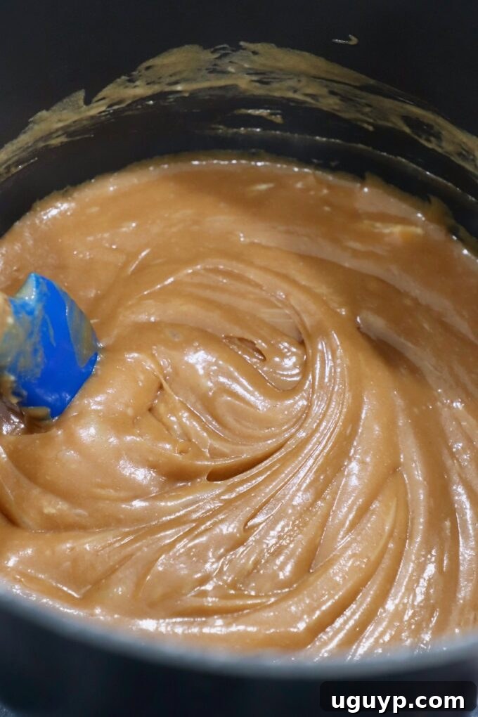 Fully melted peanut butter marshmallow sauce in the pot on the stove, smooth and ready to mix.