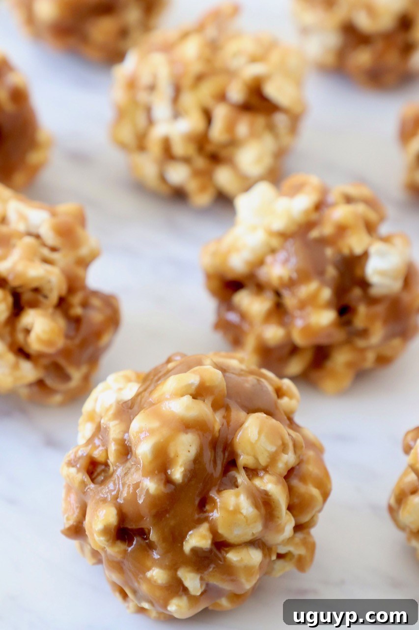 Freshly made Peanut Butter Popcorn Balls displayed on a elegant white serving tray, ready for any occasion.