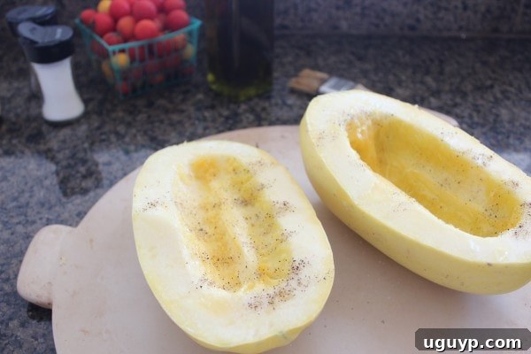 Spaghetti squash cut in half lengthwise, ready for roasting on a baking stone.