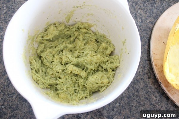 A close-up of spaghetti squash strands being pulled out with a fork after roasting.