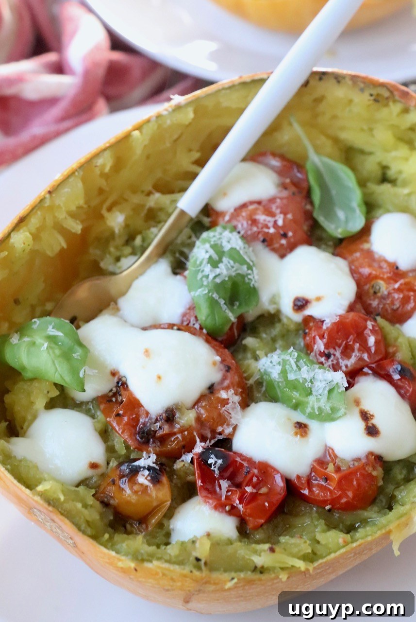 Two halves of Caprese Spaghetti Squash, richly filled and garnished with fresh basil, ready to be served.