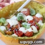 Roasted spaghetti squash filled with roasted tomatoes and melted mozzarella cheese, ready to serve.