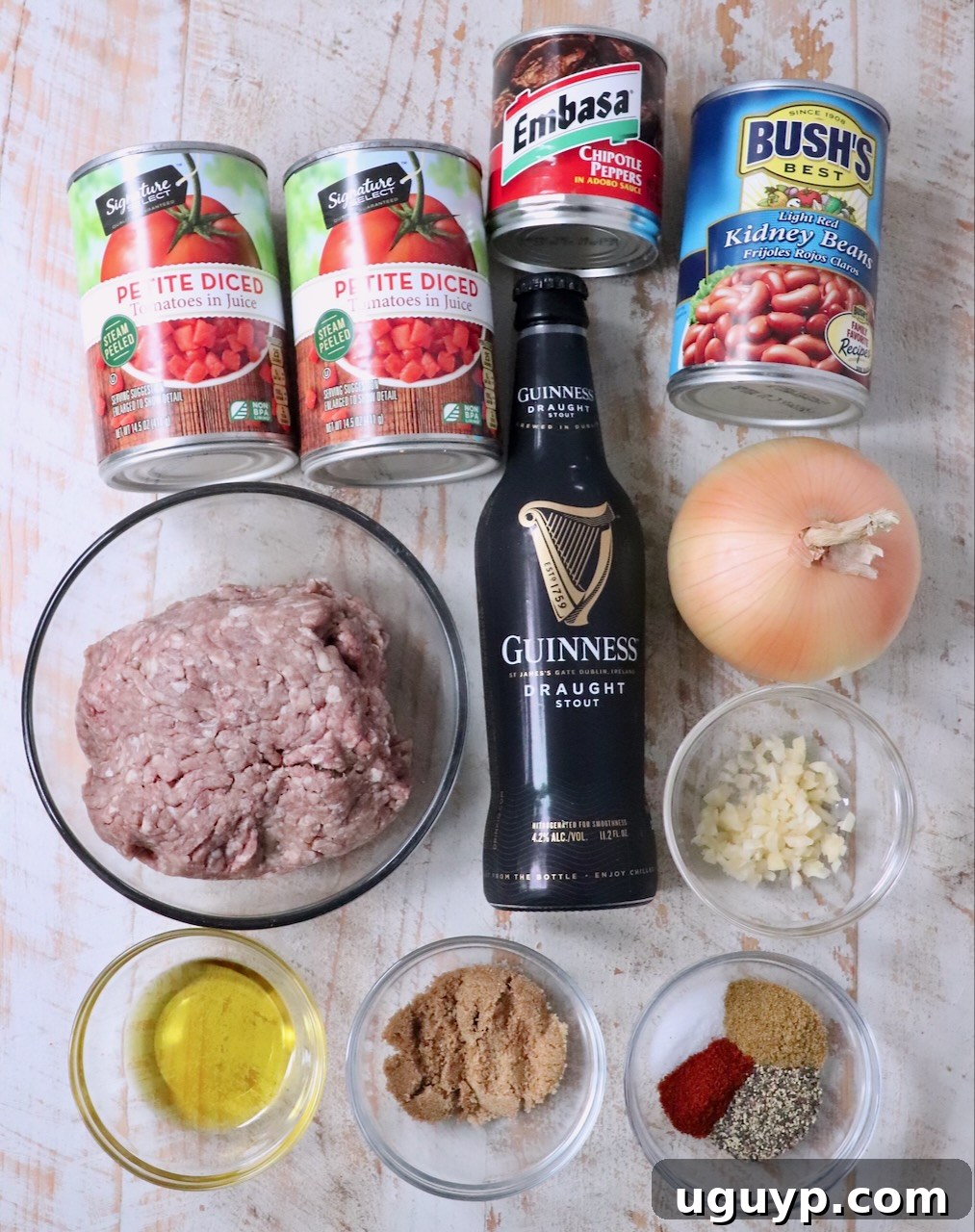 ingredients for chipotle stout chili on a white wood board