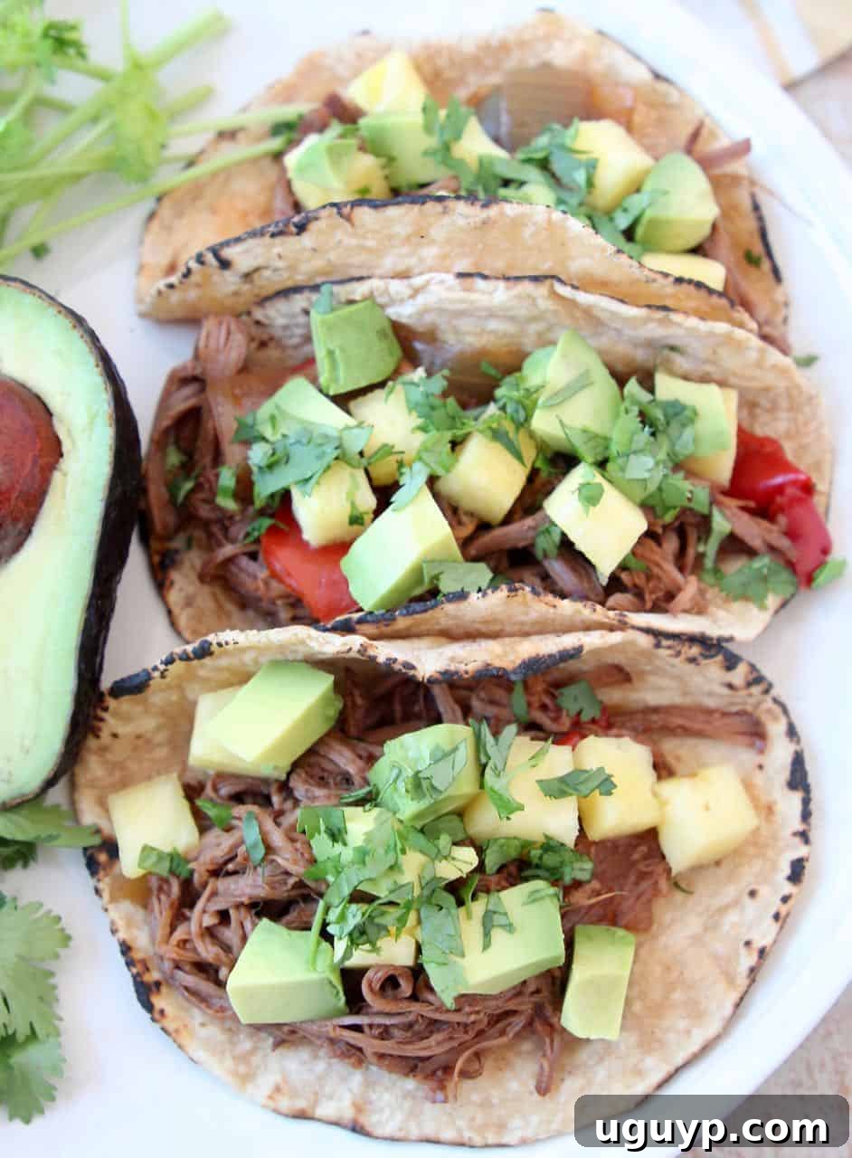 Three shredded tri tip tacos on plate with avocado