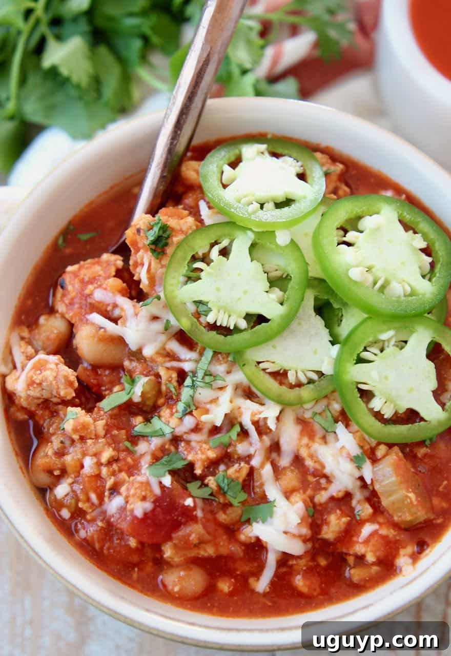 Buffalo chicken chili in bowl topped with fresh sliced jalapenos