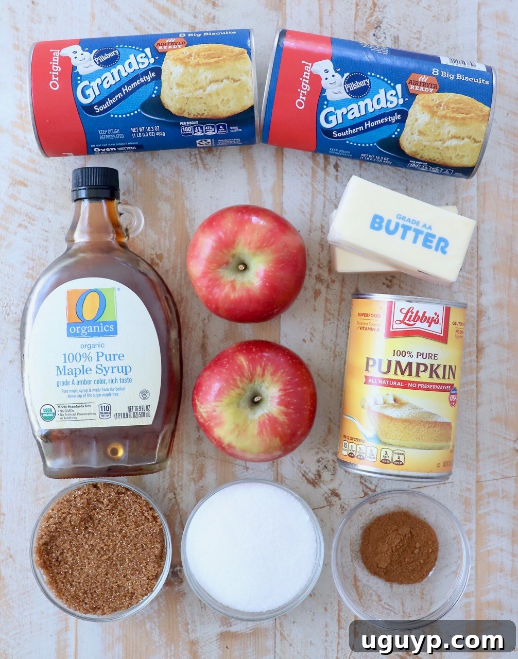 All the fresh ingredients laid out for making Pumpkin Apple Monkey Bread, including canned biscuits, apples, pumpkin puree, and spices.