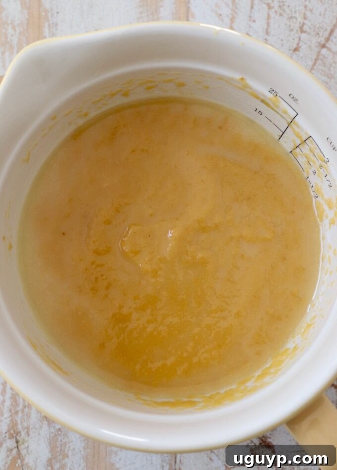 Pumpkin puree and melted butter mixed together smoothly in a bowl.