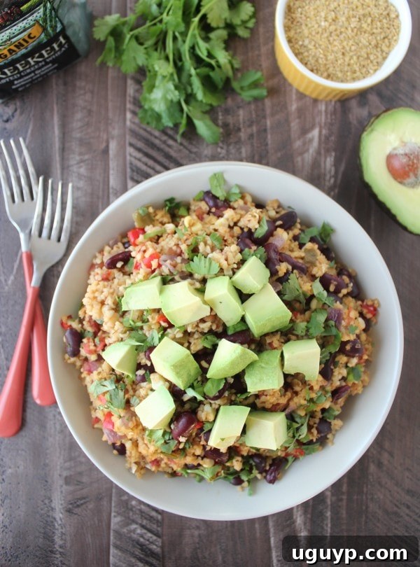 Delicious Vegan Mexican Freekeh served in a bowl, garnished with fresh cilantro and avocado.