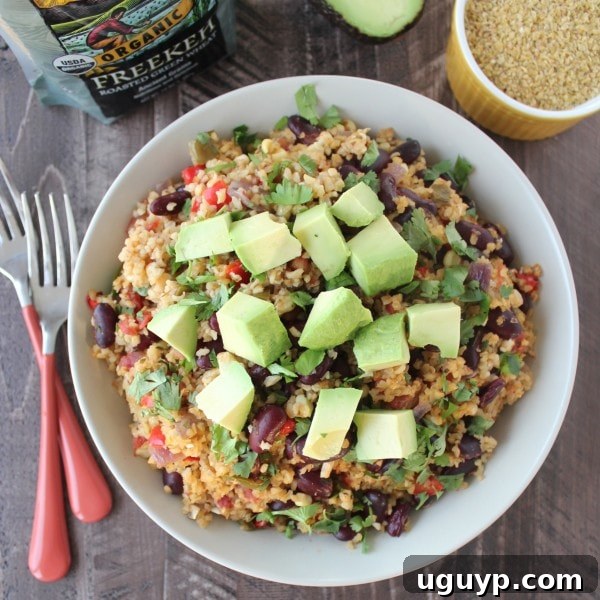 Close-up of the finished One Pot Vegan Mexican Freekeh, garnished with cilantro and avocado.