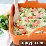 Mexican casserole in orange baking dish with wooden spoon